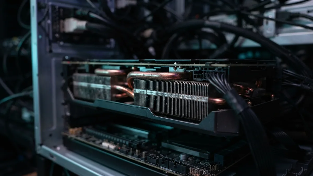 Fotografia em grande aproximação das aletas de um dissipador de calor de uma GPU de servidor iluminada por LEDs azul e roxo.
