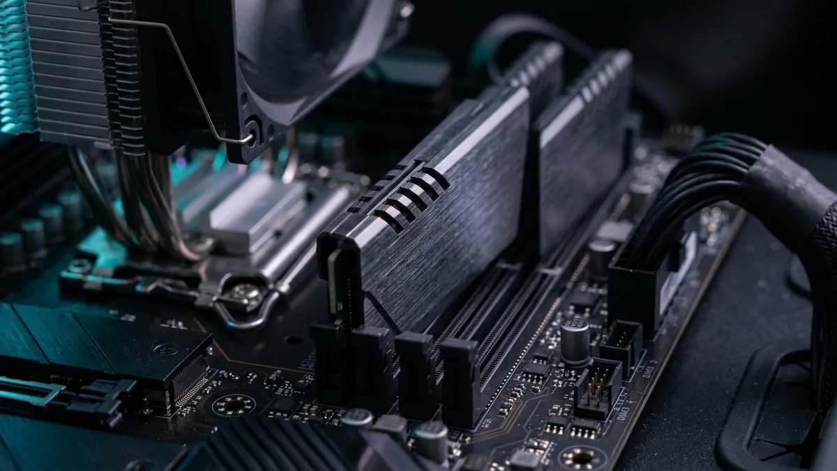 Fotografia em detalhe de módulos de memória RAM DDR5 instalados em uma placa-mãe de alta performance com iluminação suave.